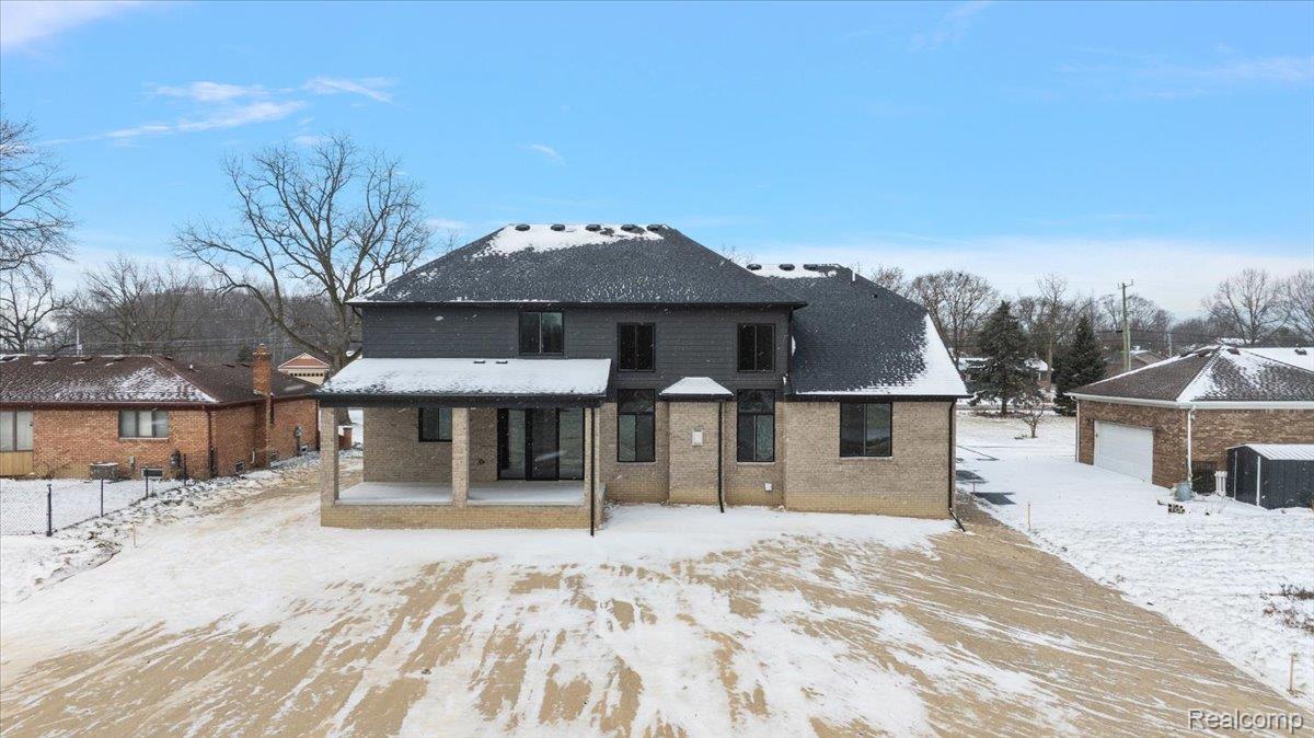 53650 Romeo Plank Road Macomb, MI 48042 - Photo 56 of 64 Snow covered back of property with a patio area and brick siding