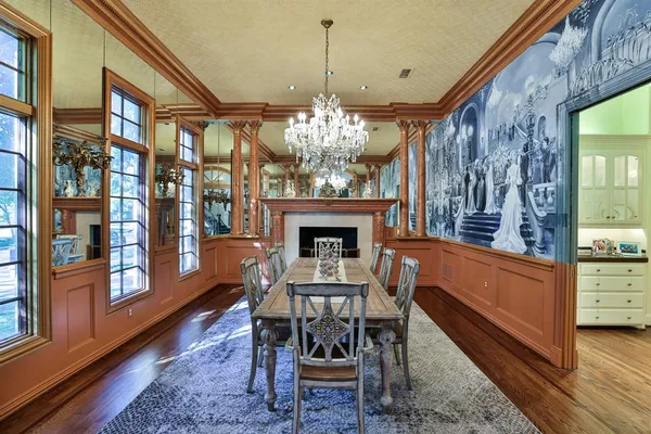 a dining room with furniture a chandelier and wooden floor