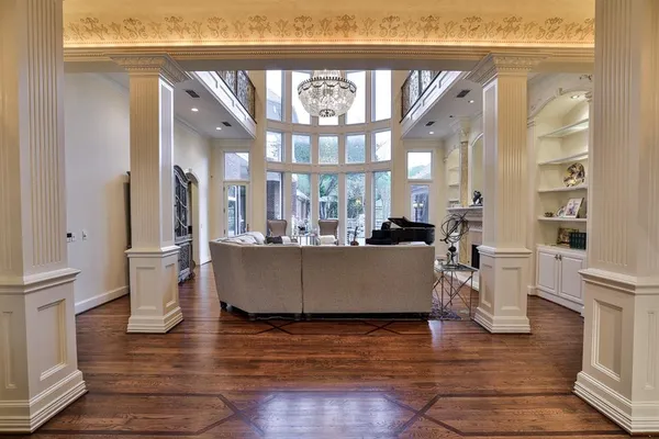 a living room with couches a coffee table and a large mirror with wooden floor
