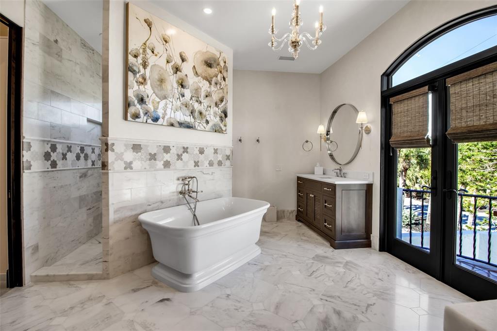 121 North Casey Key Road Osprey, FL 34229 - Photo 24 of 63 a spacious bathroom with a bathtub sink and mirror