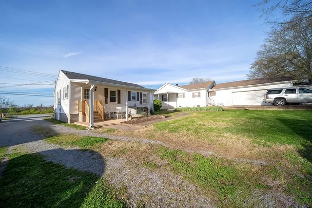 a view of a house with yard and porch