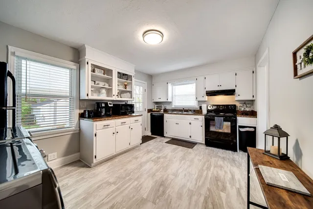 a kitchen with granite countertop a stove top oven sink and cabinets