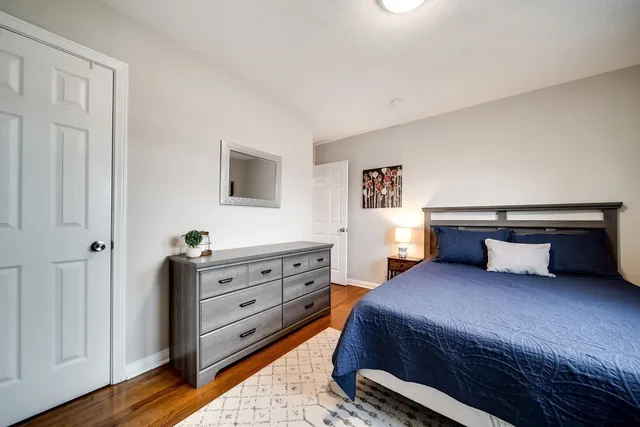 a spacious bedroom with a bed and a dresser