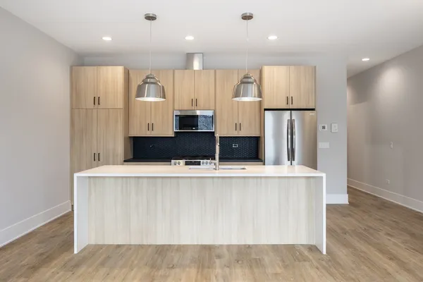 a large kitchen with stainless steel appliances a refrigerator and a stove top oven