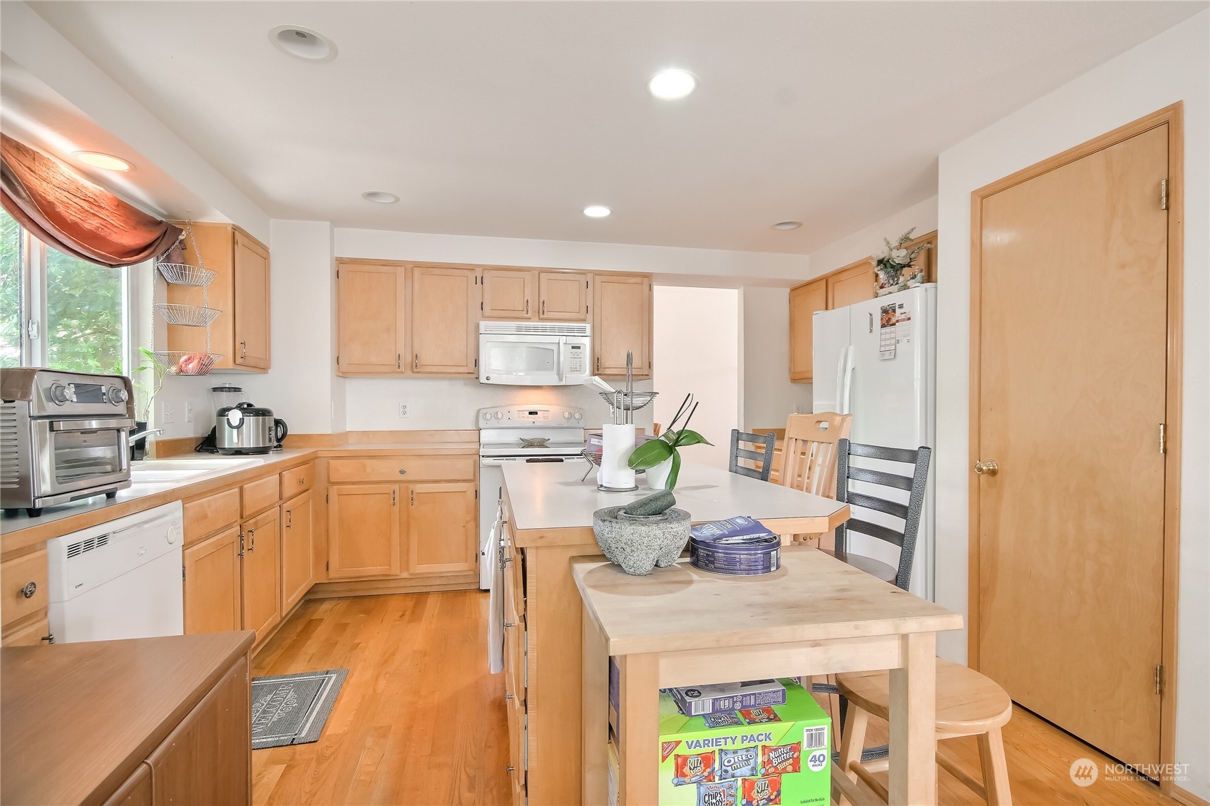 19910 142nd Place Southeast Renton, WA 98058 - Photo 11 of 38 a kitchen with a refrigerator a sink dishwasher with a dining table and chairs