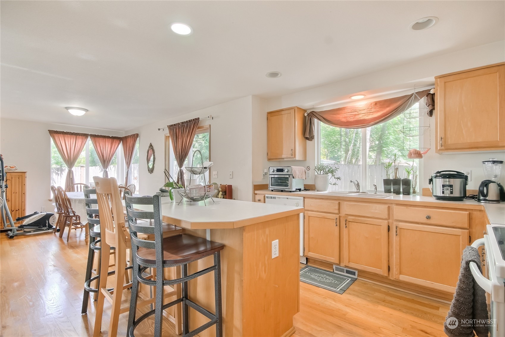 19910 142nd Place Southeast Renton, WA 98058 - Photo 13 of 38 a kitchen with stainless steel appliances granite countertop a stove a sink dishwasher and cabinets with wooden floor