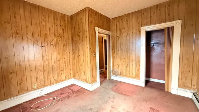 a view of a room with wooden walls and window