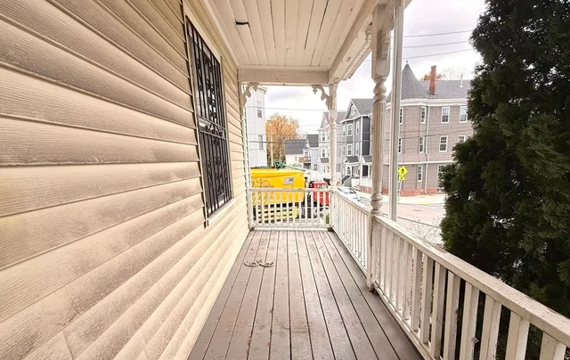 a view of a balcony with a floor to ceiling window with wooden floor