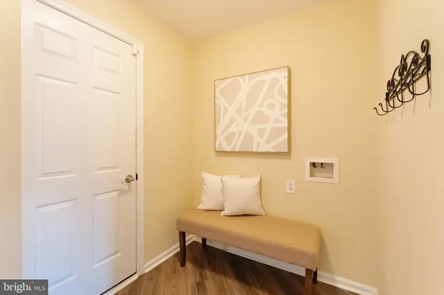 a front view of a house with lots of flower garden and plants