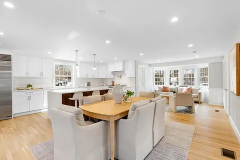 a view of a kitchen with kitchen island white cabinets and stainless steel appliances