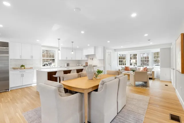 a view of a kitchen with kitchen island white cabinets and stainless steel appliances
