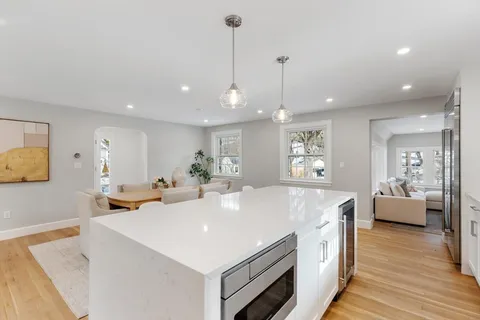 a kitchen with a dining table chairs and white cabinets