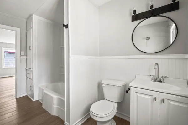 an empty room with wooden floor chandelier fan and windows