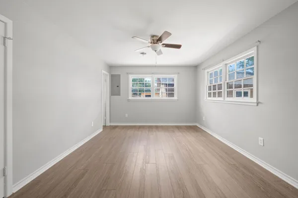 a view of a livingroom with wooden floor and a ceiling fan