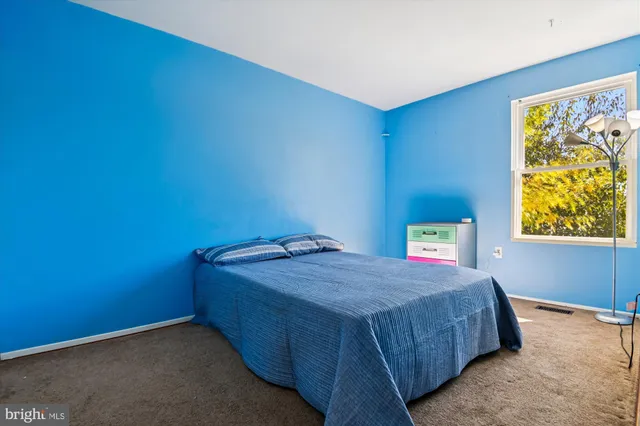 a bedroom with a bed and painting on the wall
