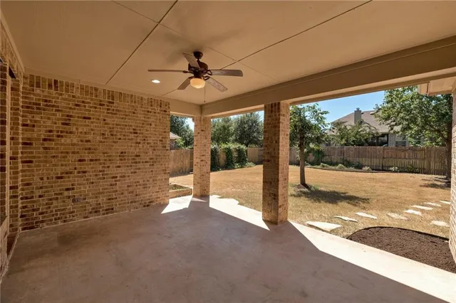 a view of a porch with a table and chairs under an umbrella
