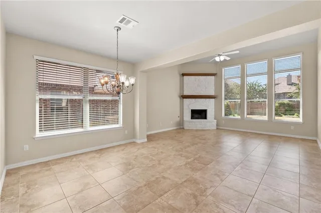 a view of an empty room with a fireplace and a window