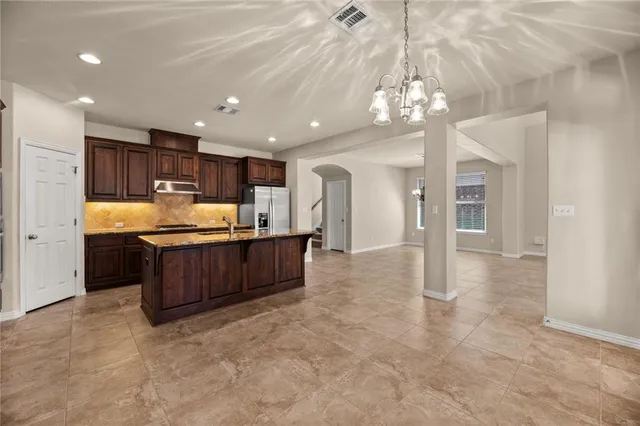 a view of kitchen with stainless steel appliances granite countertop a refrigerator and a sink