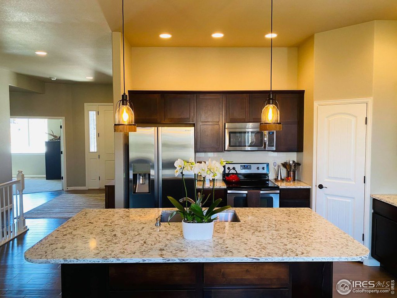 505 Deville Drive Greeley, CO 80634 - Photo 15 of 39 a kitchen with kitchen island a stove and a wooden floor