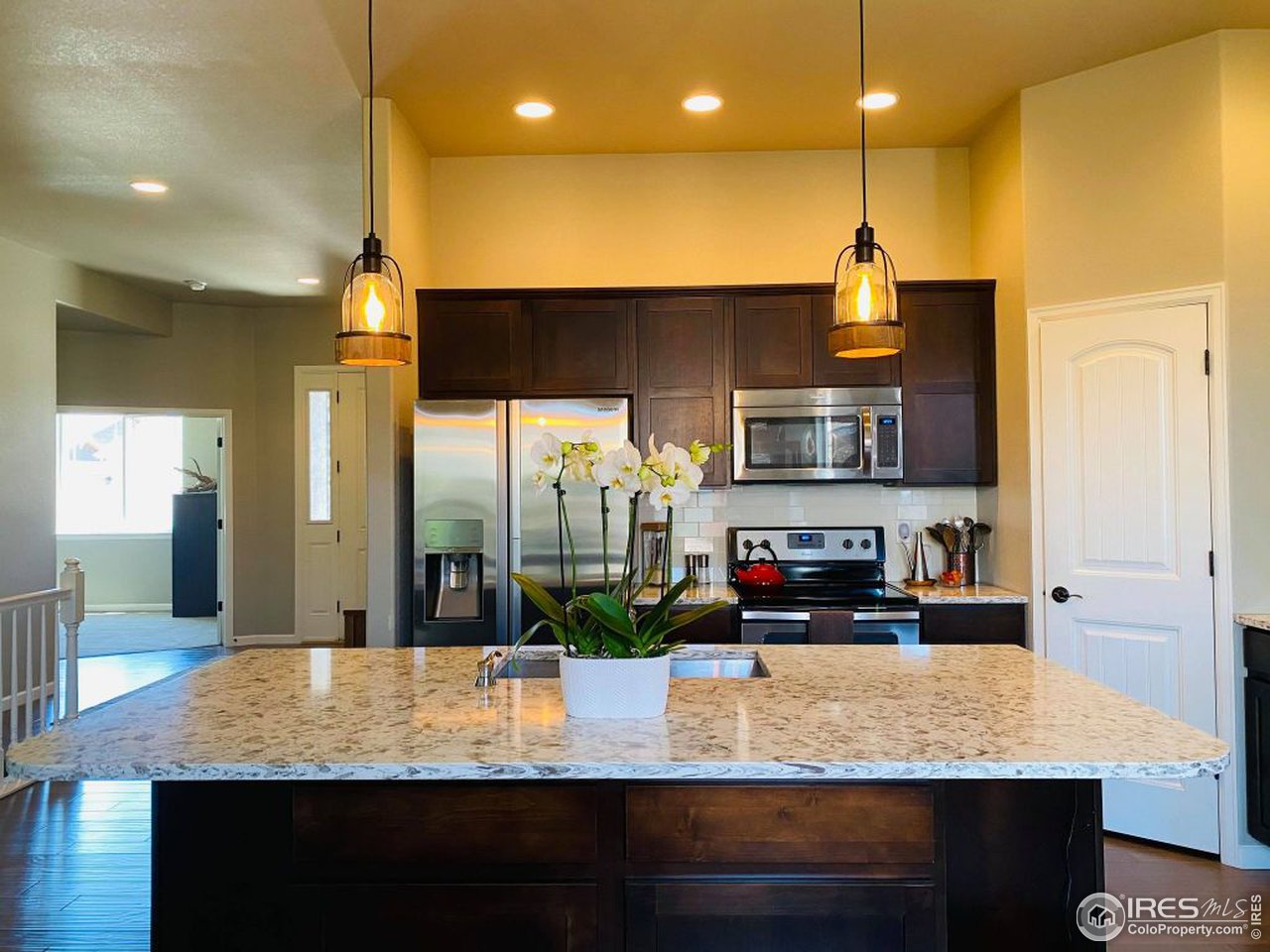 505 Deville Drive Greeley, CO 80634 - Photo 16 of 39 a kitchen with sink a refrigerator and chairs