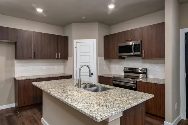 a kitchen with granite countertop a stove and a microwave