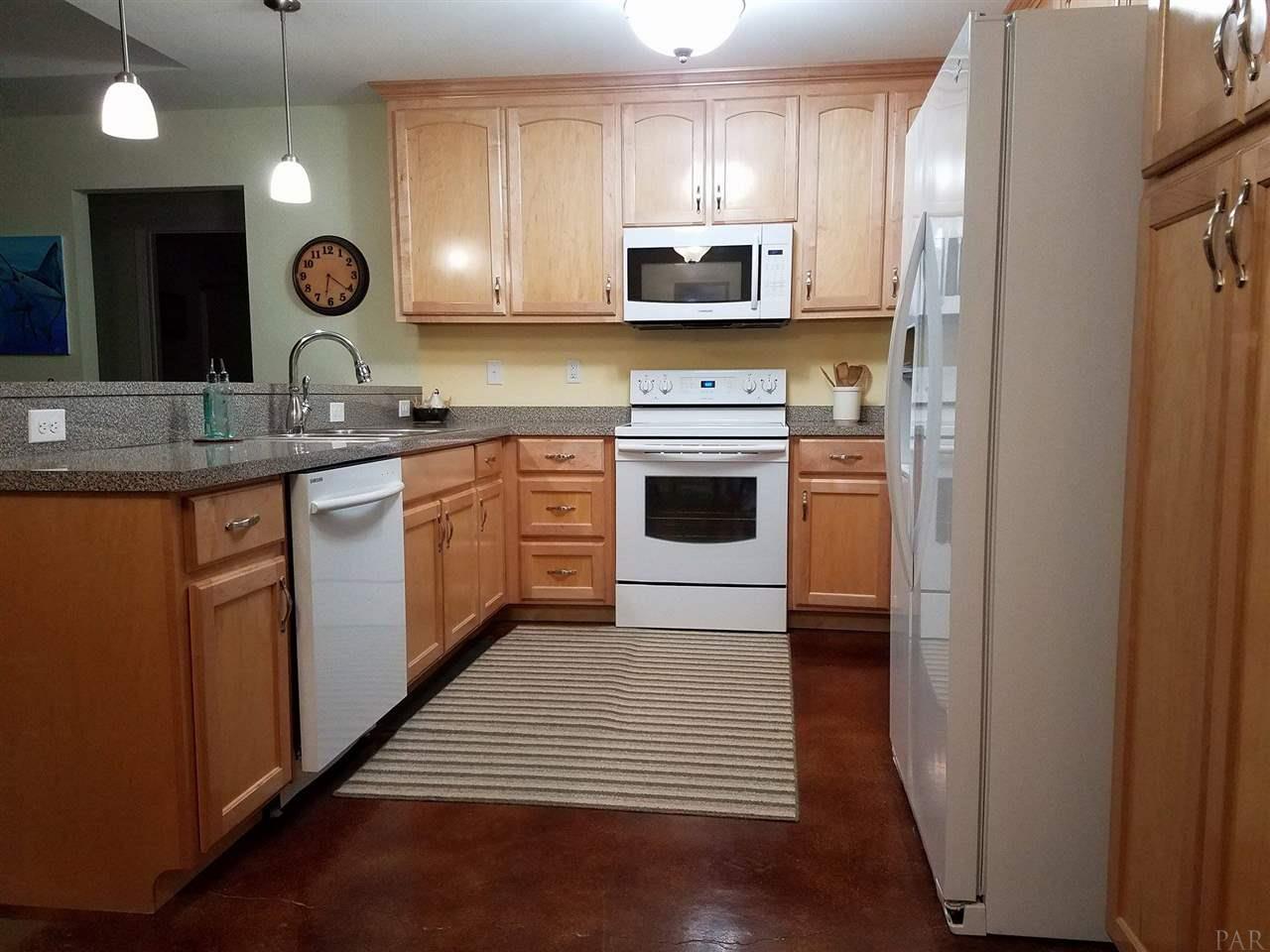 4708 Old Guernsey Road Pace, FL 32571 - Photo 10 of 46 a large kitchen with stainless steel appliances granite countertop a stove a sink and a microwave