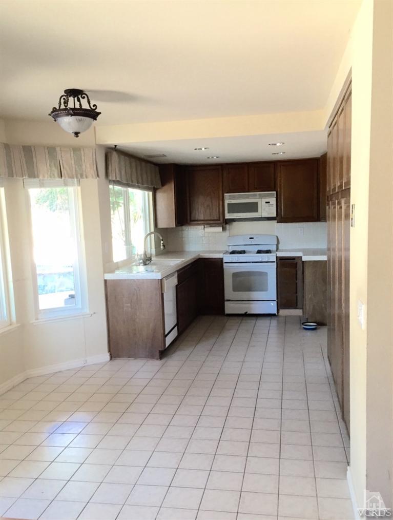 823 Warren Court Moorpark, CA 93021 - Photo 7 of 20 a kitchen with stainless steel appliances granite countertop a stove a sink and a refrigerator