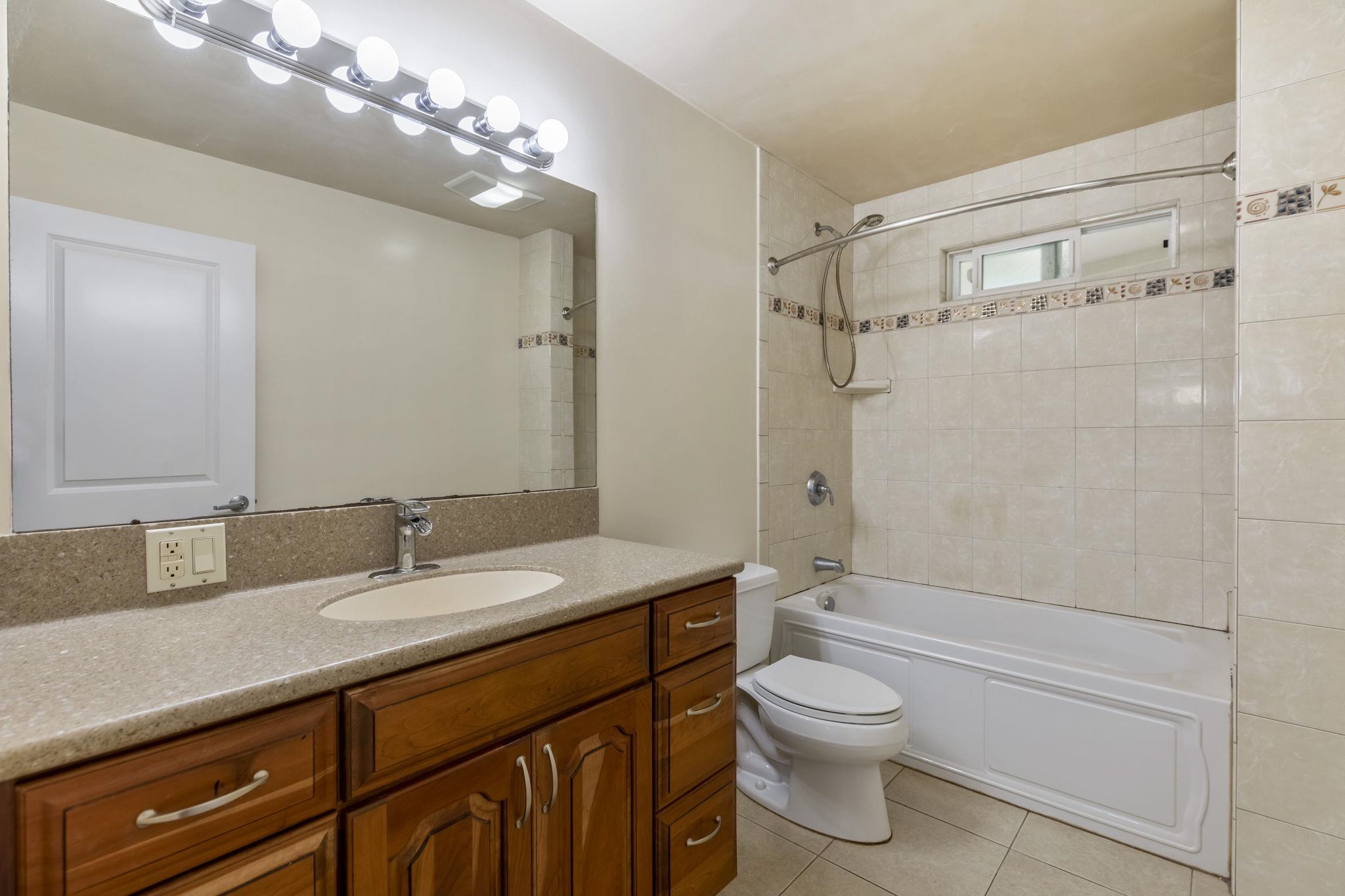 44 Pokoa Place Haiku, HI 96708 - Photo 20 of 29 a bathroom with a granite countertop sink toilet a shower and a mirror