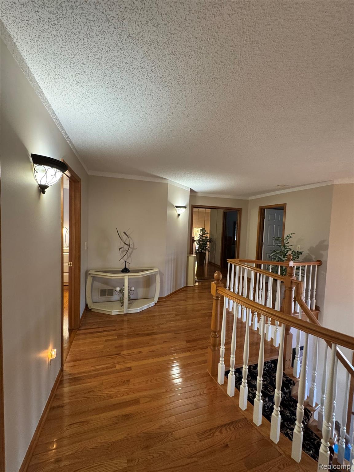 48583 Tilch Road Macomb, MI 48044 - Photo 28 of 53 Hall with an upstairs landing, hardwood / wood-style floors, a textured ceiling, and ornamental molding