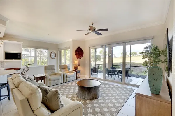 a kitchen with stainless steel appliances granite countertop a dining table chairs and refrigerator