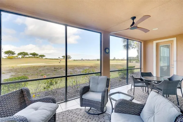 a living room with furniture and floor to ceiling windows