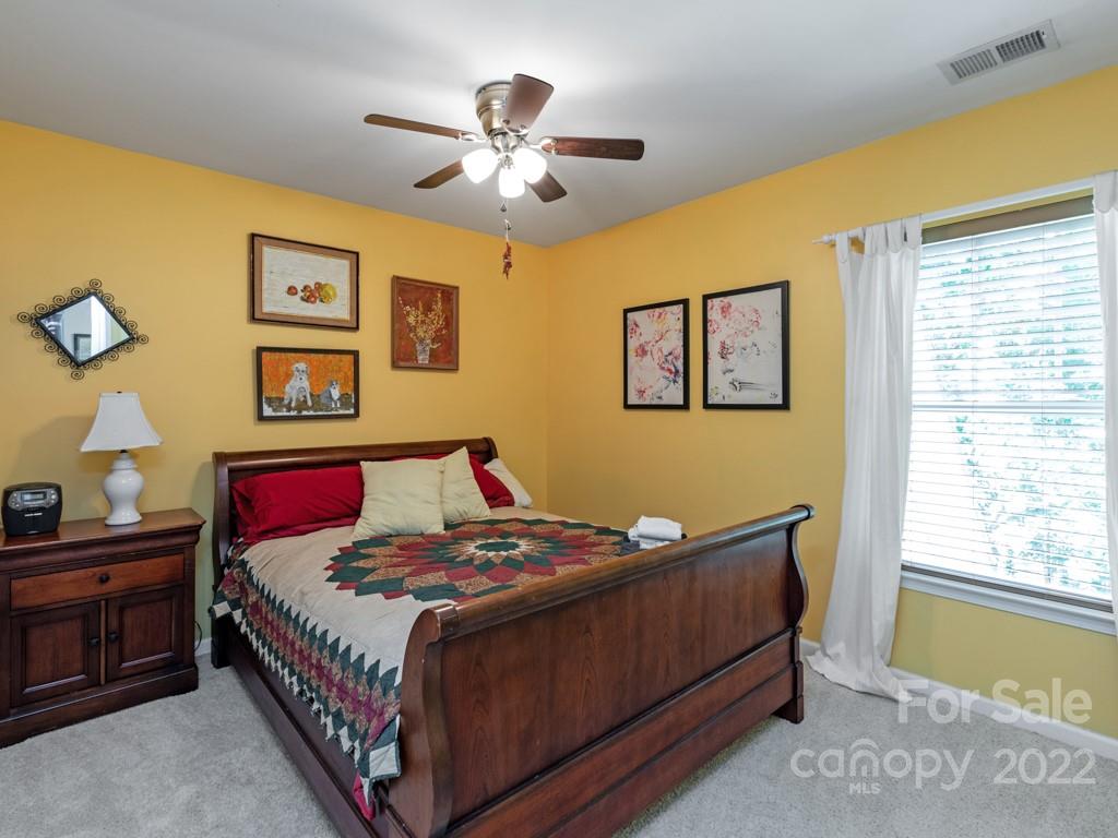 392 Sand Paver Way Fort Mill, SC 29708 - Photo 16 of 35 a bedroom with a bed and a chandelier