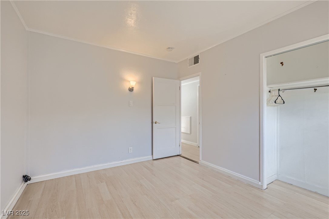 103 West Victory Road Henderson, NV 89015 - Photo 19 of 28 Unfurnished bedroom with light wood-style floors, baseboards, and ornamental molding