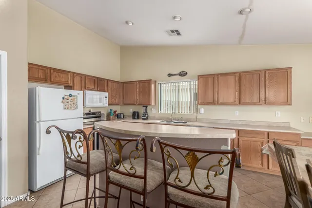 a kitchen with stainless steel appliances granite countertop a table chairs sink and cabinets