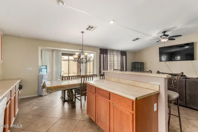 a large kitchen with kitchen island a sink a counter space and a dining table view