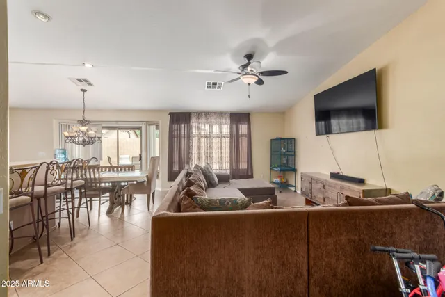 a living room with furniture kitchen view and a flat screen tv