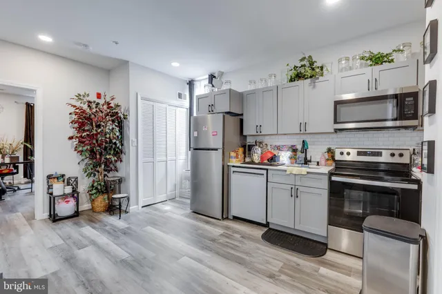 a kitchen with granite countertop a refrigerator and a stove top oven