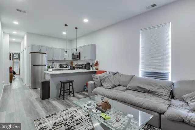 a living room with furniture and kitchen view