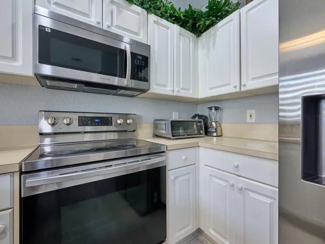 a living room with furniture a computer on the desk and a window