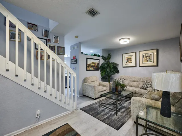 a view of staircase with furniture and lots of frames on wall