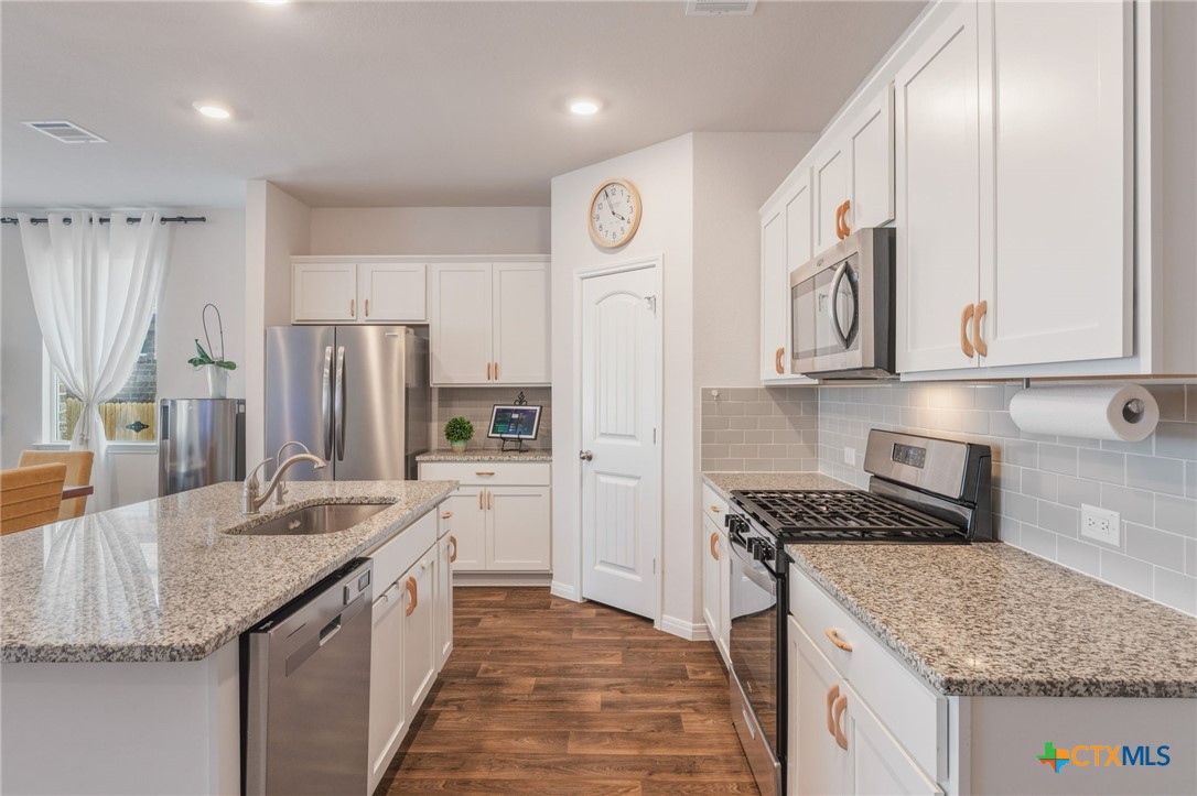 205 Charles Trail Georgetown, TX 78626 - Photo 6 of 38 a kitchen with stainless steel appliances granite countertop a sink stove and refrigerator