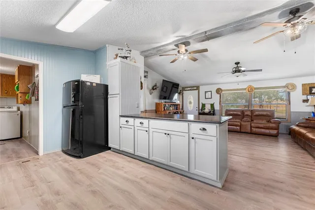 a kitchen with refrigerator and cabinets