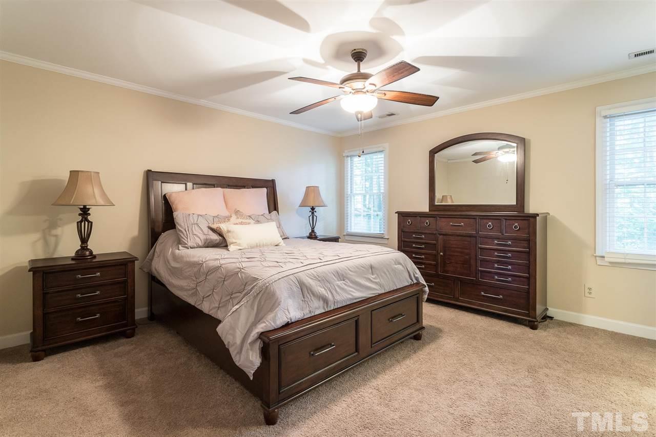 1025 Sawmill Road Raleigh, NC 27615 - Photo 18 of 25 a spacious bedroom with a bed and a chandelier