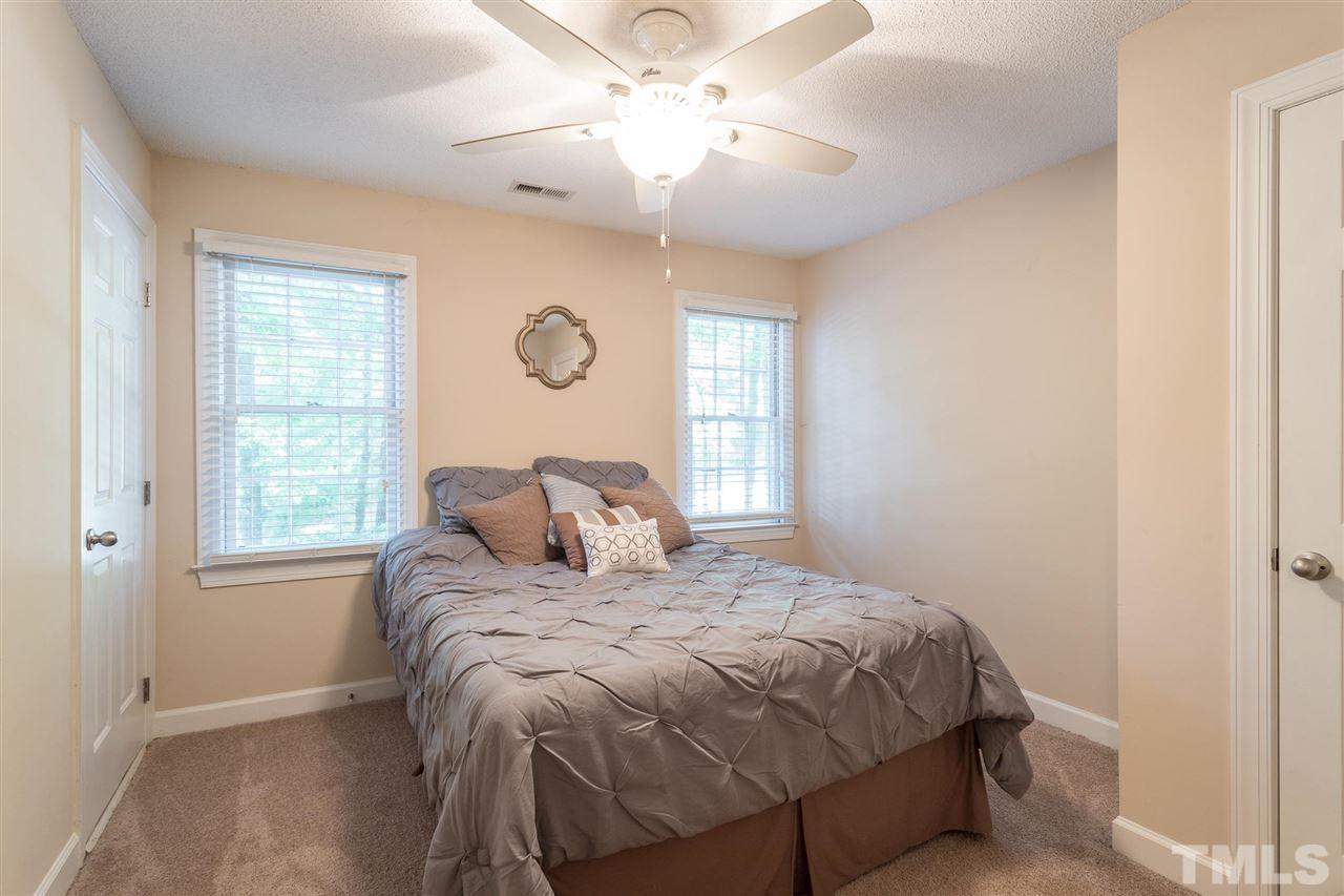 1025 Sawmill Road Raleigh, NC 27615 - Photo 21 of 25 a bedroom with a bed and a chandelier