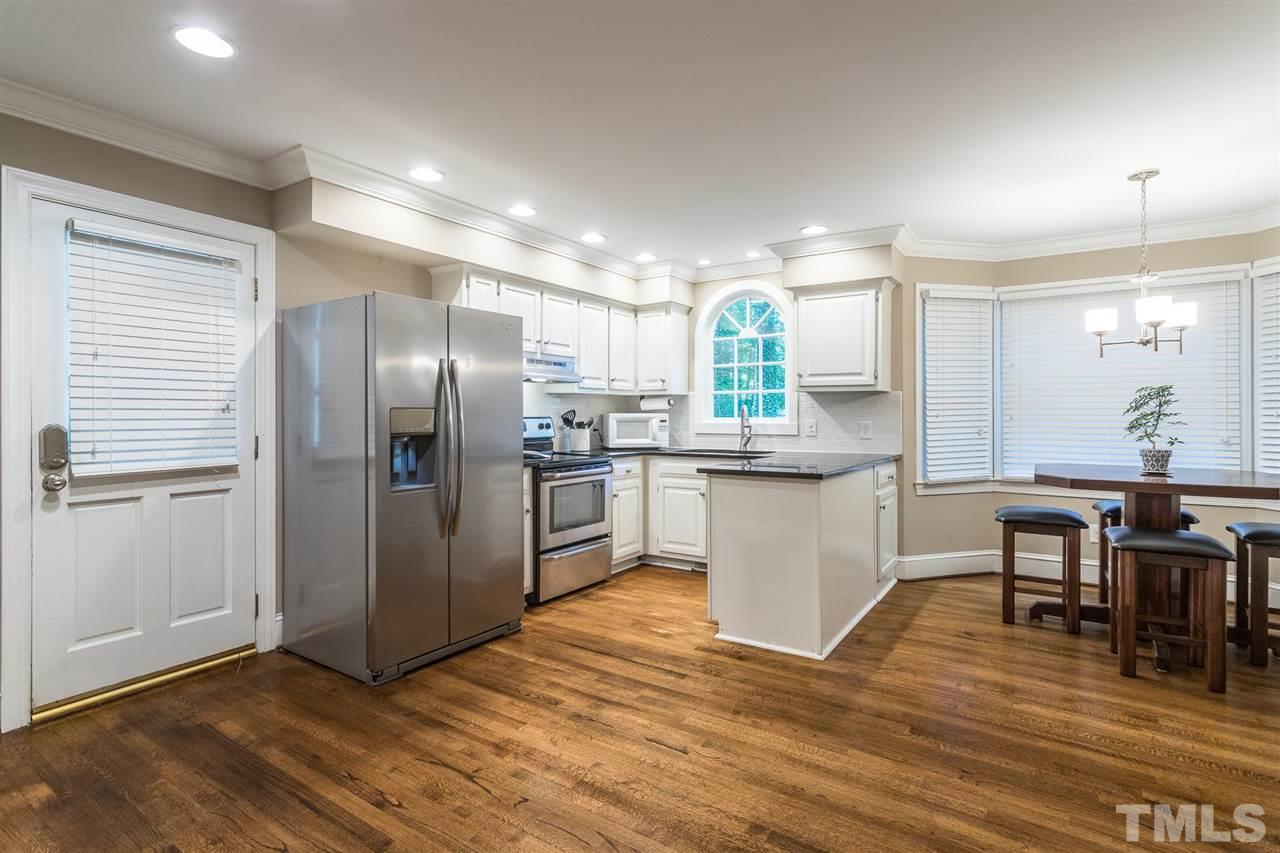 1025 Sawmill Road Raleigh, NC 27615 - Photo 4 of 25 a kitchen with stainless steel appliances kitchen island granite countertop a refrigerator a stove a sink dishwasher with a dining table and chairs
