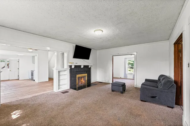 a living room with furniture a fireplace and a flat screen tv