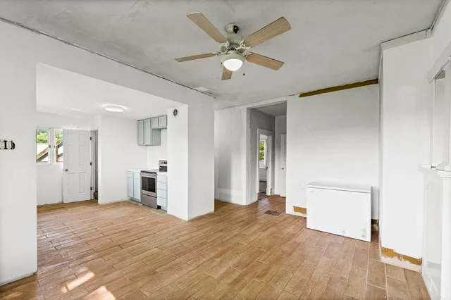 a view of a livingroom with a chandelier fan and wooden floor