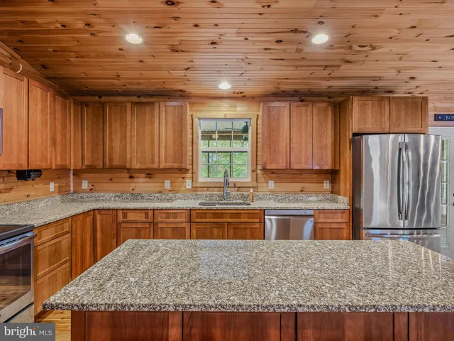 a kitchen with granite countertop sink table and chairs