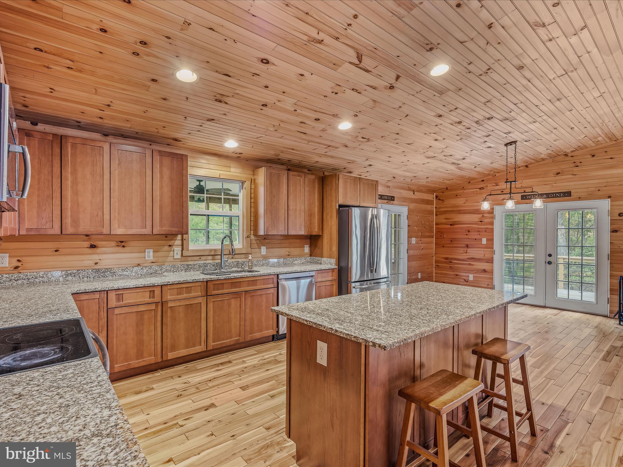 79 Whiskey Still Road Berkeley Springs, WV 25411 - Photo 18 of 59 a kitchen with granite countertop sink table and chairs