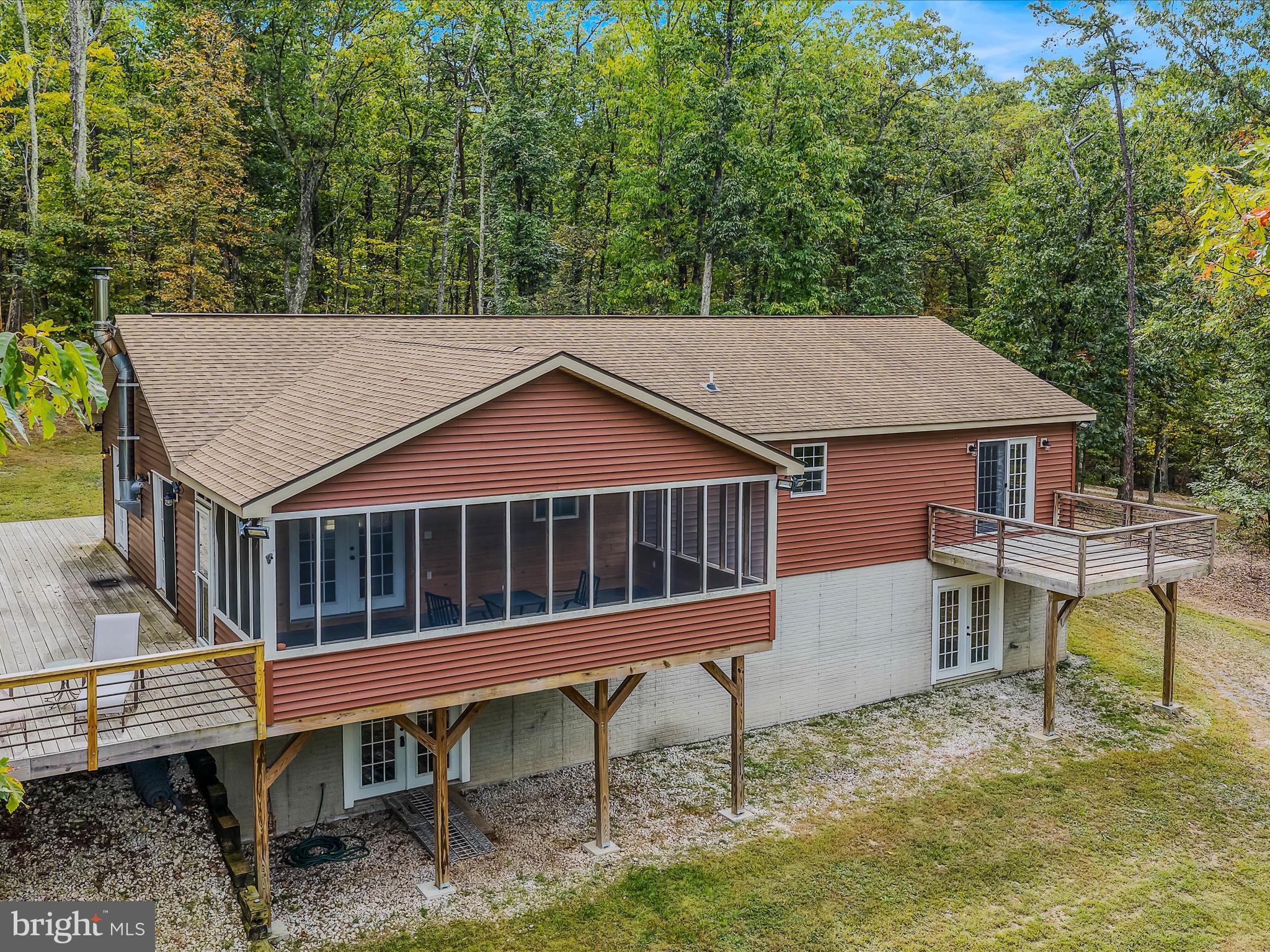 79 Whiskey Still Road Berkeley Springs, WV 25411 - Photo 2 of 59 aerial view of a house with a deck and a yard